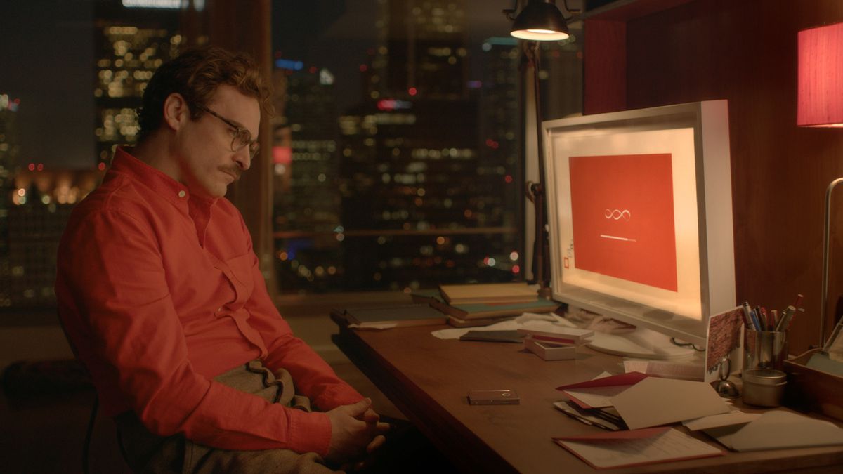 Theodore (Joaquin Phoenix) sitting in front of a computer in Her.