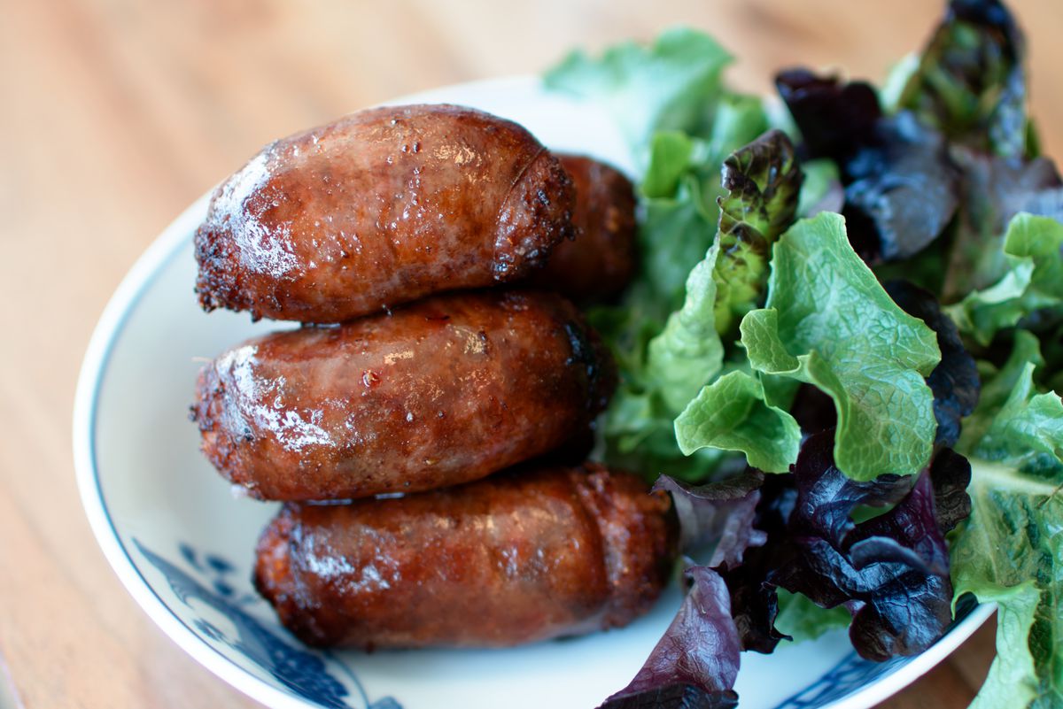 A close-up picture of a pile of tiny sausages on a plate.