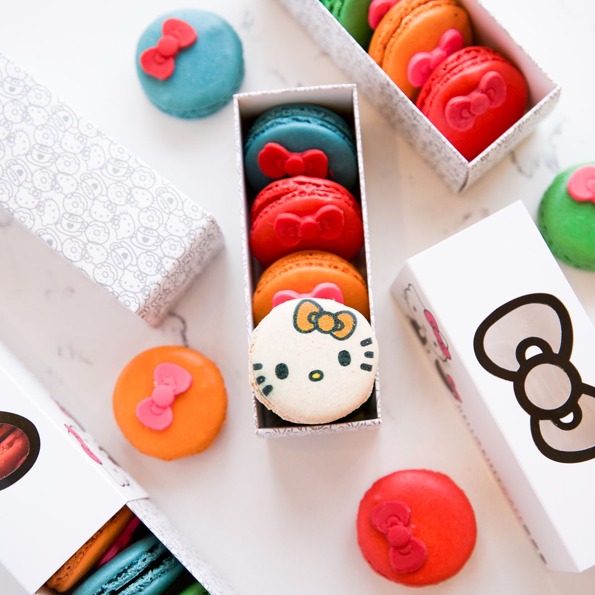 A rectangular box filled with macarons with Hello Kitty faces on them.