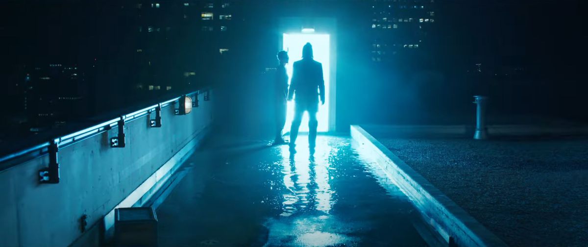 Neo walks through a lit-up doorway on the rooftops, guided by Bugs, in The Matrix Resurrections
