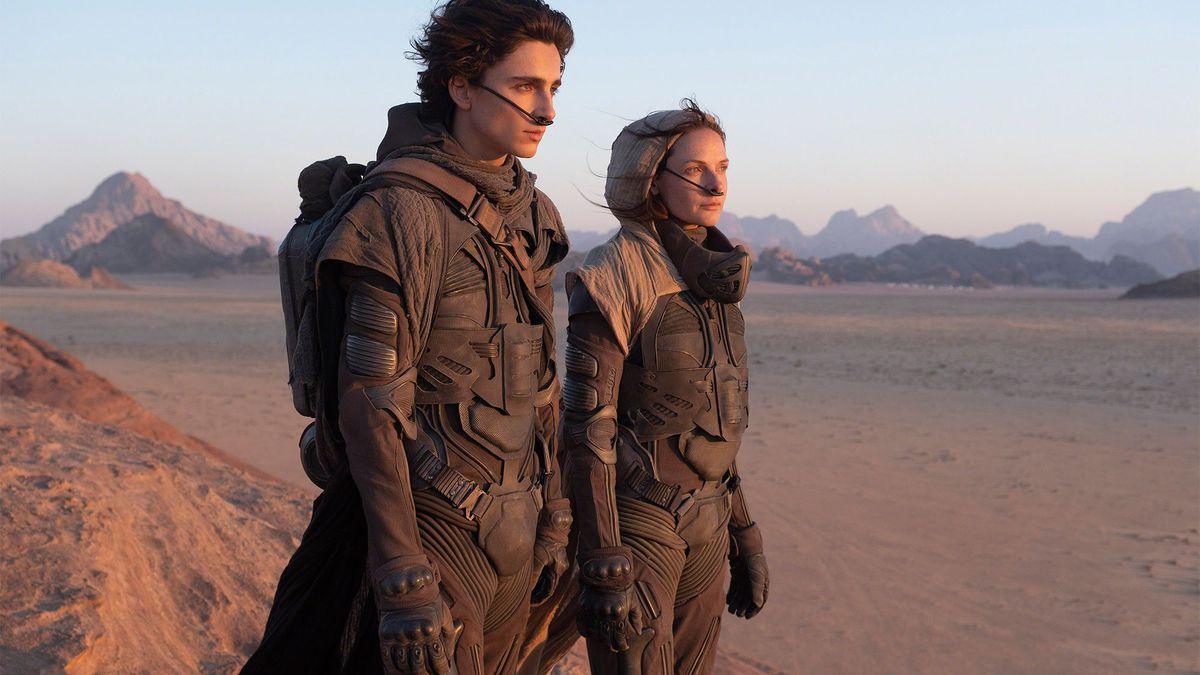 Timothée Chalamet as Paul Atreides and Rebecca Furguson as Lady Jessica Atreides stand in the desert on the set of Denis Villenueve’s Dune.