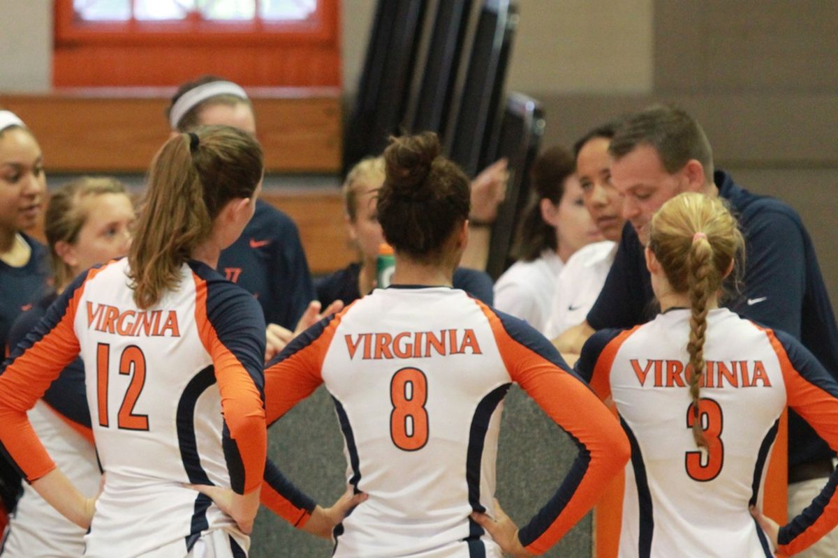 Virginia Volleyball Natalie Bausback (#12), Tori Janowski (#8) and Sydney Shelton (#3) and their teammates listen to Coach Dennis Hohenshelt during a timeout in the Orange and Blue Scrimmage on August 18, 2012. Photo by Tim Mulholland