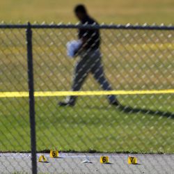 Evidence markers are seen on on the ground as police investigate the shooting of a 16-year-old boy outside Union Middle School in Sandy on Tuesday, Oct. 25, 2016.