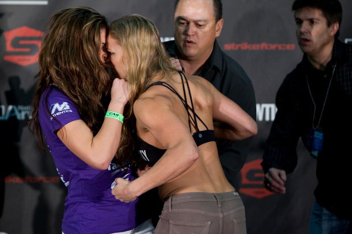 Photo of Miesha Tate (left) and Ronda Rousey (right) butting heads via Strikeforce. 