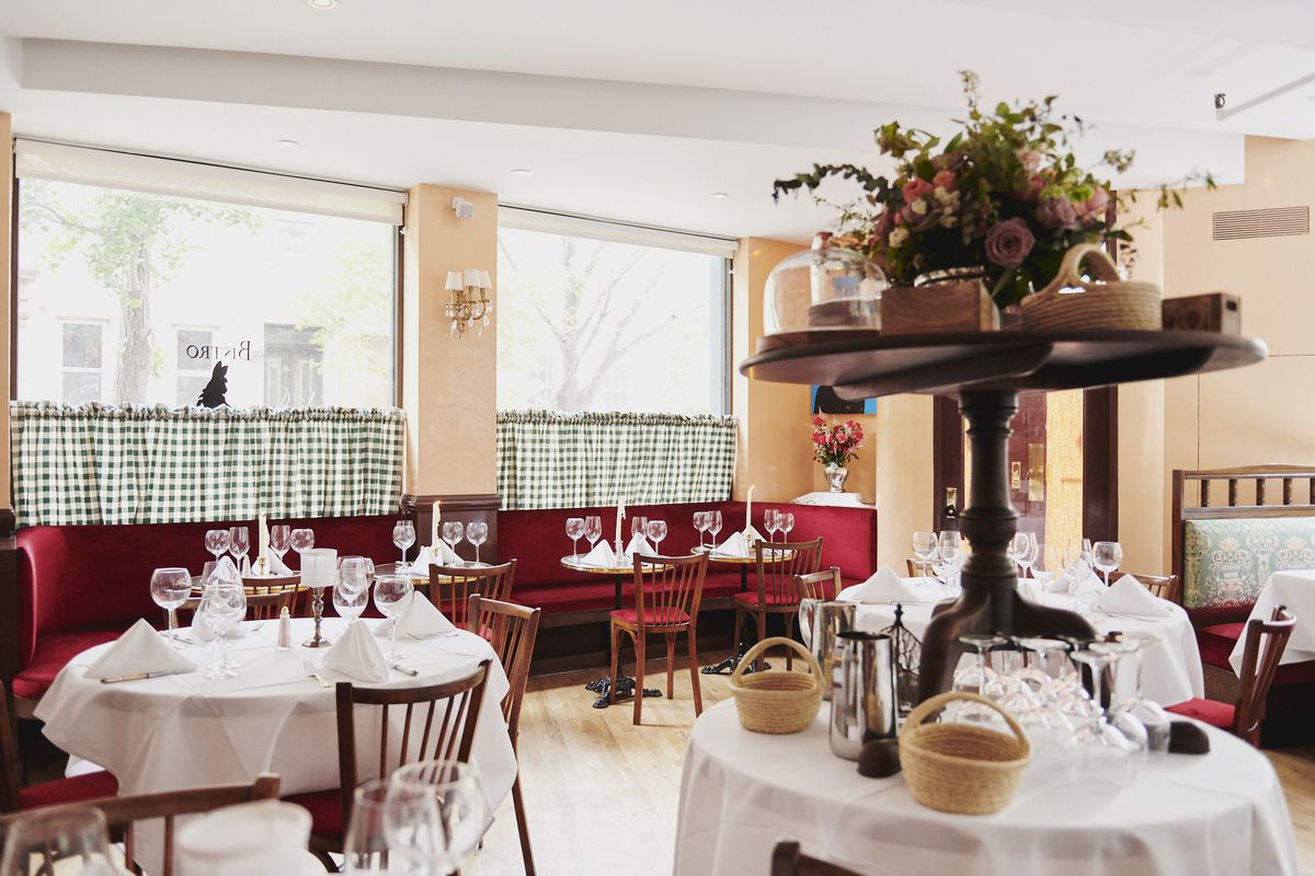 Bistro Pierre Lapin’s dining room with white tablecloths and checkered windows