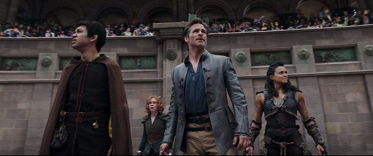 The four party members in Dungeons &amp; Dragons: Honor Among Thieves —&nbsp;Simon (Justice Smith), Doric (Sophia Lillis), Edgin (Chris Pine) and Holga (Michelle Rodriguez) stand in front of a crowd in a gladiatorial arena, and look collectively worried