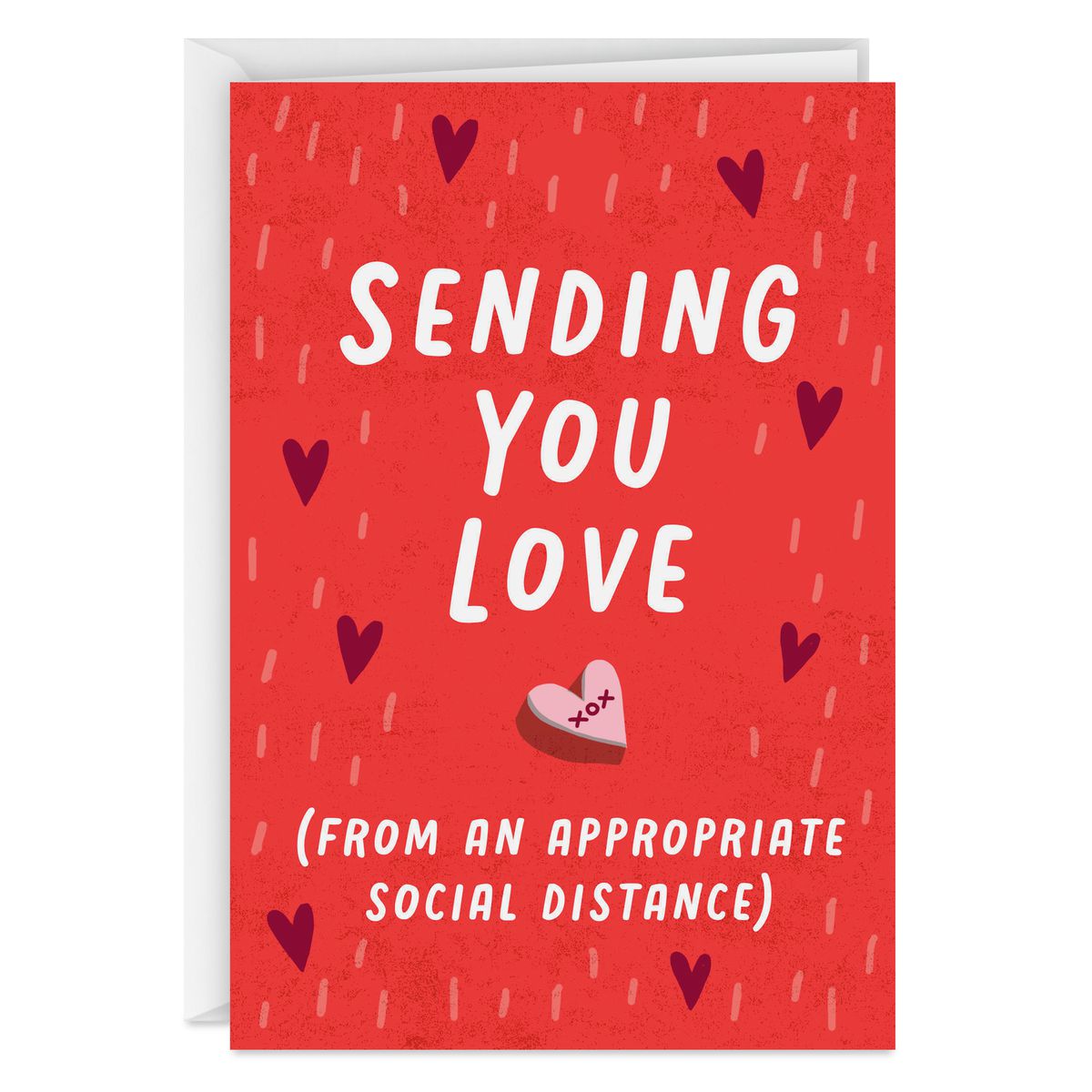 A card with a candy heart reading “Sending you love (from an appropriate social distance)”