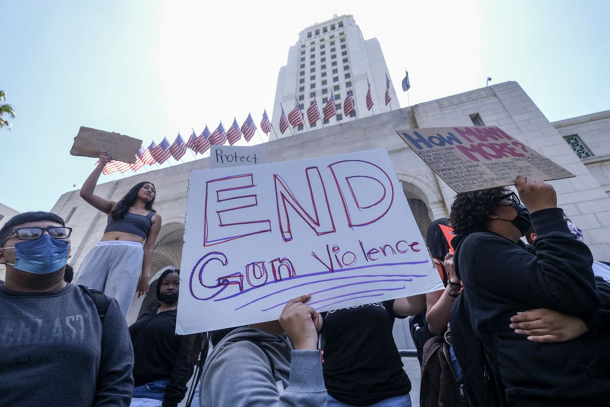 A student holds a protest sign that reads “End gun violence.”