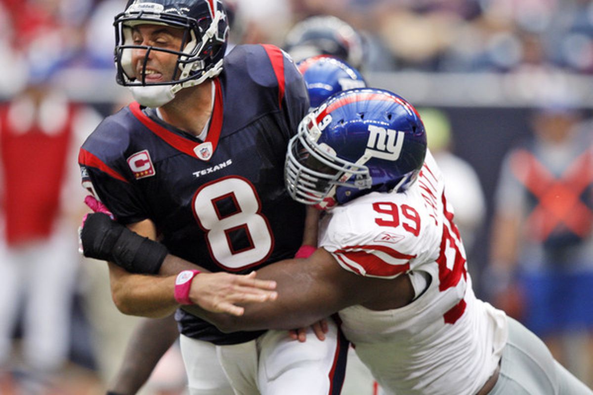 HOUSTON - OCTOBER 10:  Quarterback Matt Schaub #8 of the Houston Texans is hit by defensive tackle Chris Canty #99 of the New York Giants at Reliant Stadium on October 10, 2010 in Houston, Texas.  (Photo by Bob Levey/Getty Images)