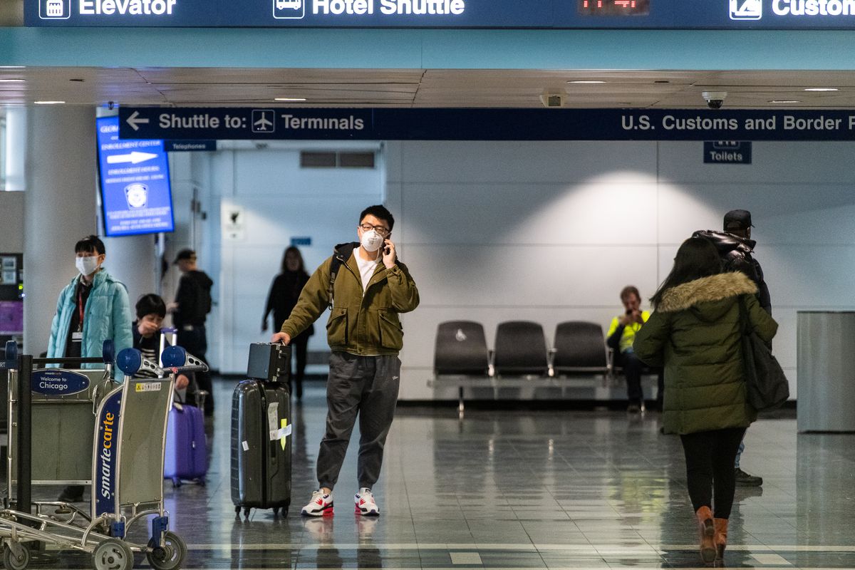 A man wearing a face mask talks on the phone, at O’Hare Airport’s international terminal in January.