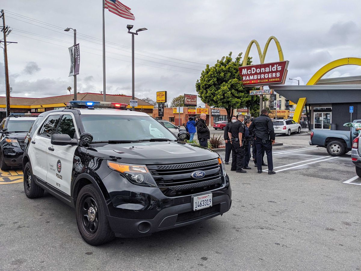 Police officers break up a protest at McDonald’s in LA on April 7