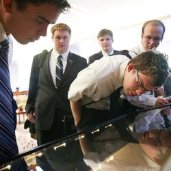 Elders Jacob Wamsley, left, William Skyler Hall, Jared Moore, Dylan Tribe and Nolan McNeely, all missionaries for The Church of Jesus Christ of Latter-day Saints, view pages from the printer's manuscript of the Book of Mormon at the Church History Library in Salt Lake City on Thursday, Sept. 21, 2017.