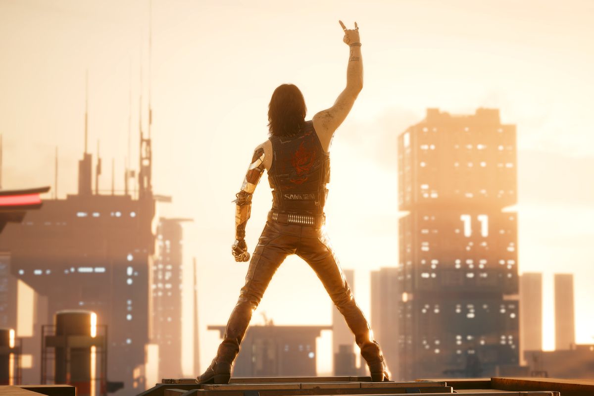 Keanu Reeves, as Johnny Silverhand, makes a devil hand gesture while looking at the Night City skyline in Cyberpunk 2077.