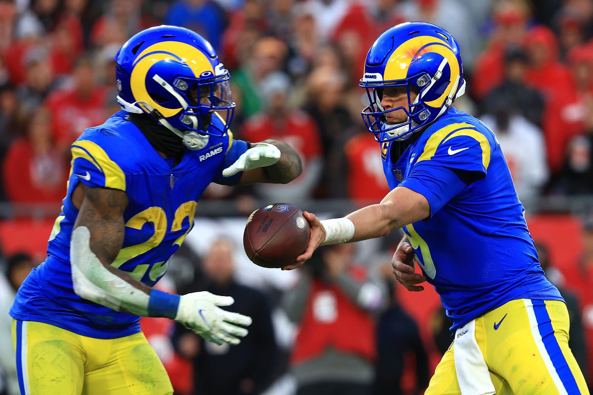 Matthew Stafford #9 of the Los Angeles Rams hands the ball off to teammate Cam Akers #23in the fourth quarter of the game against the Tampa Bay Buccaneers in the NFC Divisional Playoff game at Raymond James Stadium on January 23, 2022 in Tampa, Florida.