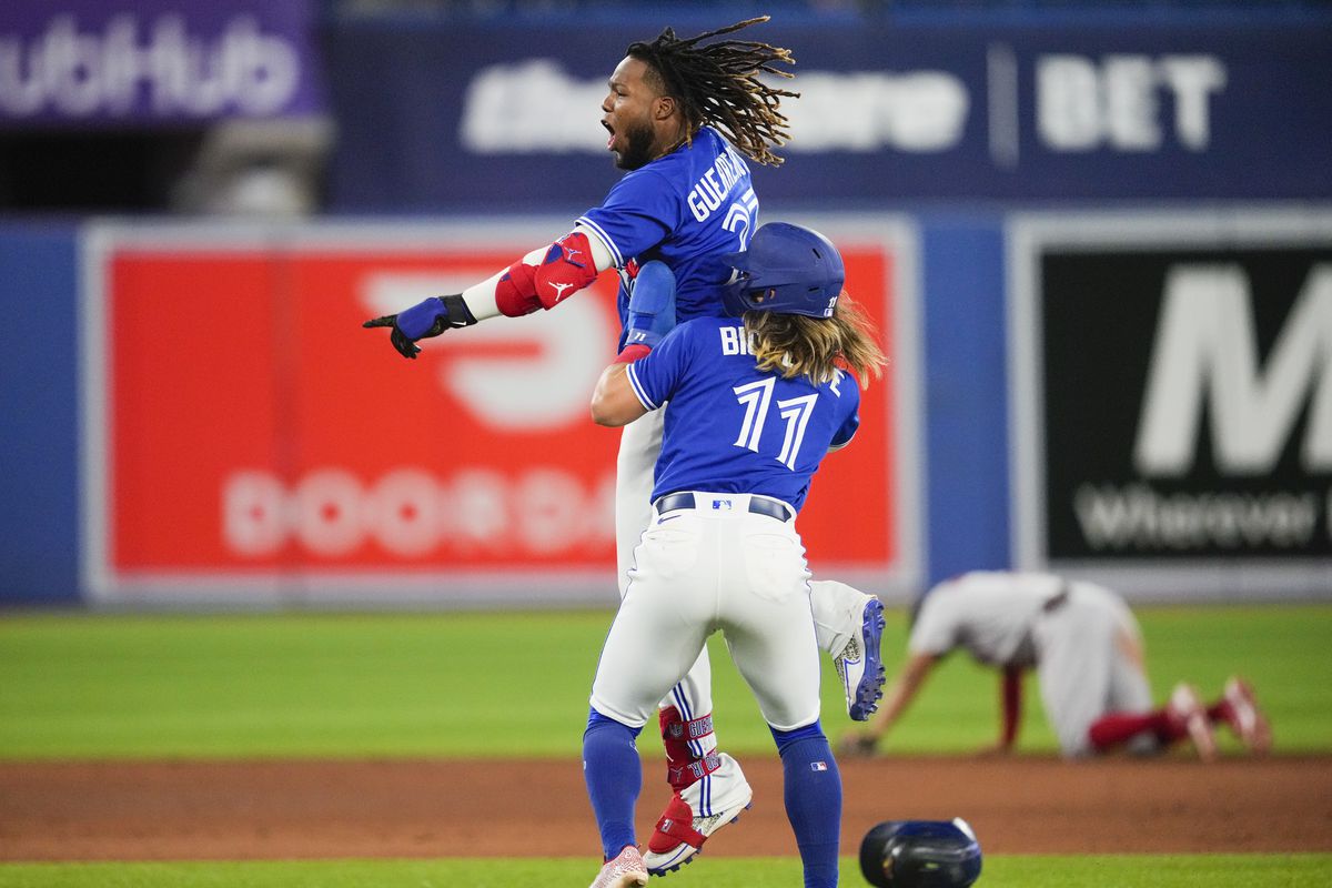 Vladimir Guerrero Jr. #27 of the Toronto Blue Jays celebrates his walk off hit to defeat the Boston Red Sox with teammate Bo Bichette #11 in the ninth inning during their MLB game at the Rogers Centre on June 28, 2022 in Toronto, Ontario, Canada.