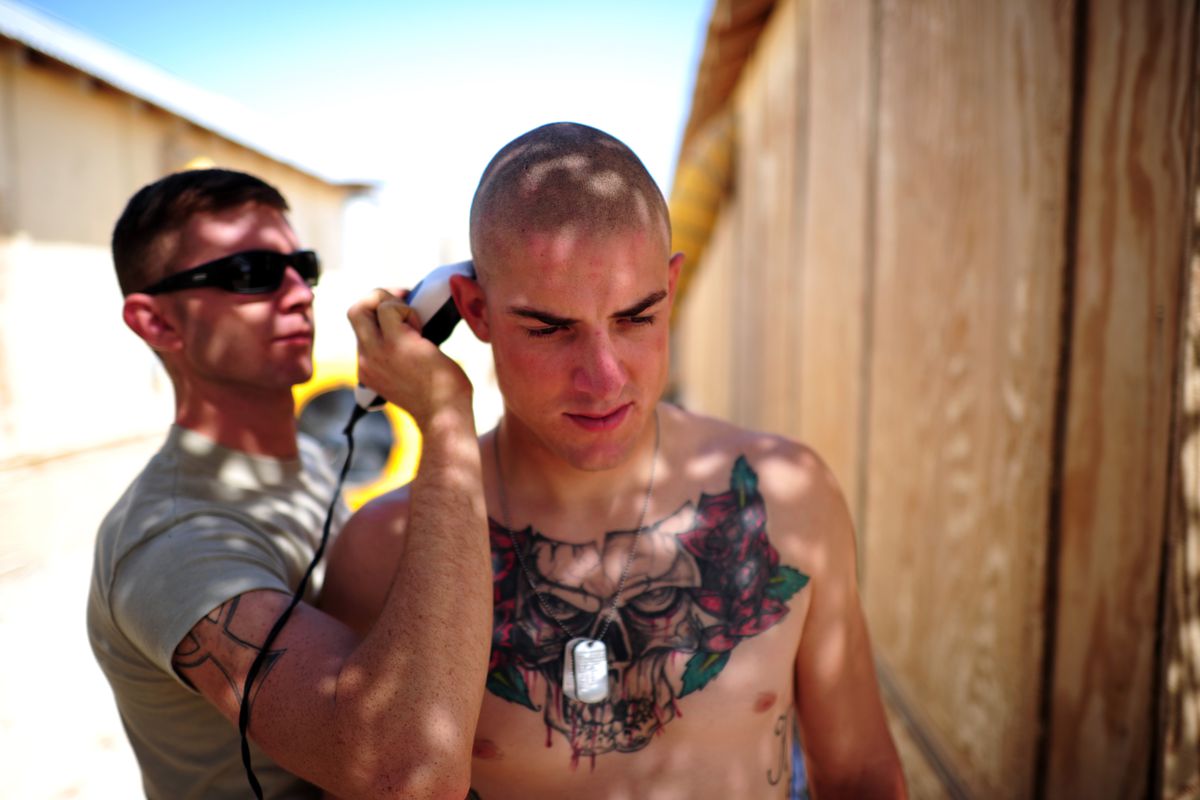US Army Private First Class Kyler King of the 2nd Platoon of Task Force 3-66, Bravo Company of the 172 Infantry Brigade gets his head shaved by PFC Shawn Riggins (also 2nd Platoon) on September 6, 2011 in Afghanistan.