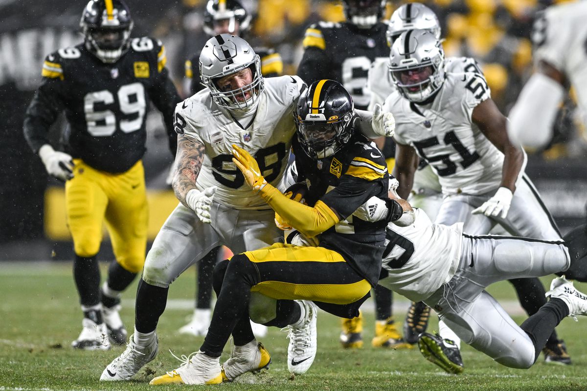 George Pickens #14 of the Pittsburgh Steelers is tackled by Maxx Crosby #98 of the Las Vegas Raiders in the third quarter at Acrisure Stadium on December 24, 2022 in Pittsburgh, Pennsylvania.