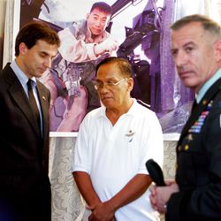 ADVANCE FOR USE FRIDAY, MAY 25, 2012 AND THEREAFTER - FILE - In this Tuesday, Feb. 7, 2006 file photo, Rosendo Garcia center, father of  U.S. Army Chief Warrant Officer Ruel Garcia receives the condolences from U.S. embassy Charges de Affrairs Paul Jones, left, and U.S. Army Brigadier General Richard Mills before the funeral in Obando, Philippines, north of Manila. Chief Warrant Officer Garcia, a pilot of the U.S. Army 4th Aviation Regiment, Aviation Brigade, 4th Infantry Division was killed in Taji, Iraq on Jan. 16, 2006. Maj. George Kraehe, a member of the Judge Advocate General's Corps, learned about the TAPS running program in 2006 during his first deployment in Iraq, and in that December he ran his first memorial race, along the perimeter of Contingency Operations Base Speicher, just north of Tikrit. He did it in honor of CW2 Ruel Garcia, 34, of Wahiawa, Hawaii. In 2009, Kraehe made a decision: to run marathons in all 50 states, honoring a native son or daughter in each. (AP Photo/Pat Roque)