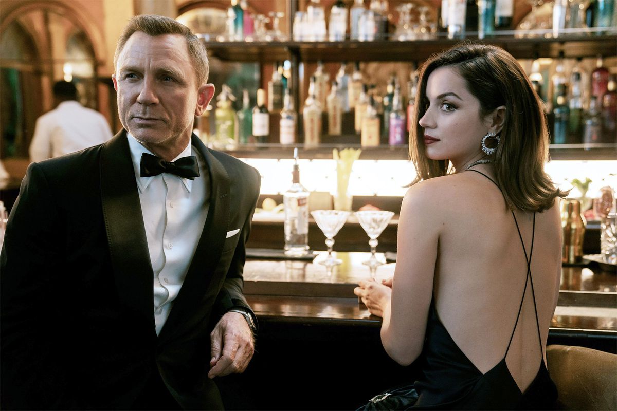 James Bond and Paloma at a bar in formalwear.