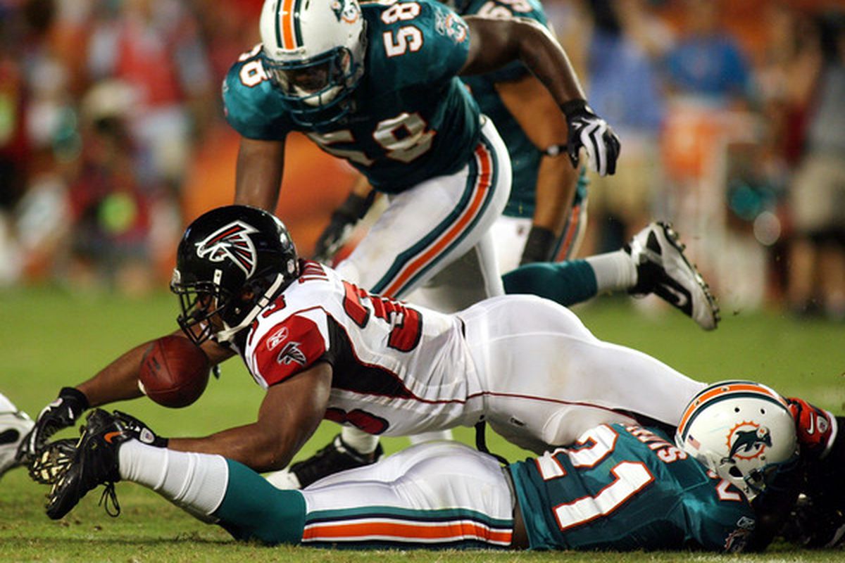 MIAMI - AUGUST 27: Running back Michael Turner #33 of the Atlanta Falcons fumbles against the Miami Dolphins during their preseason game at Sun Life Stadium on August 27 2010 in Miami Florida.  (Photo by Marc Serota/Getty Images)
