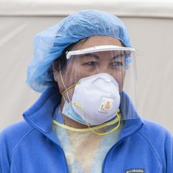 Roseland hospital staff wearing PPE stands outside near the coronavirus testing tents, while Roseland President Tim Egan thanks Robinson’s No. 1 Ribs for their donation of food to patients and staff at the hospital, Tuesday, March 31, 2020. | Tyler LaRiviere/Sun-Times