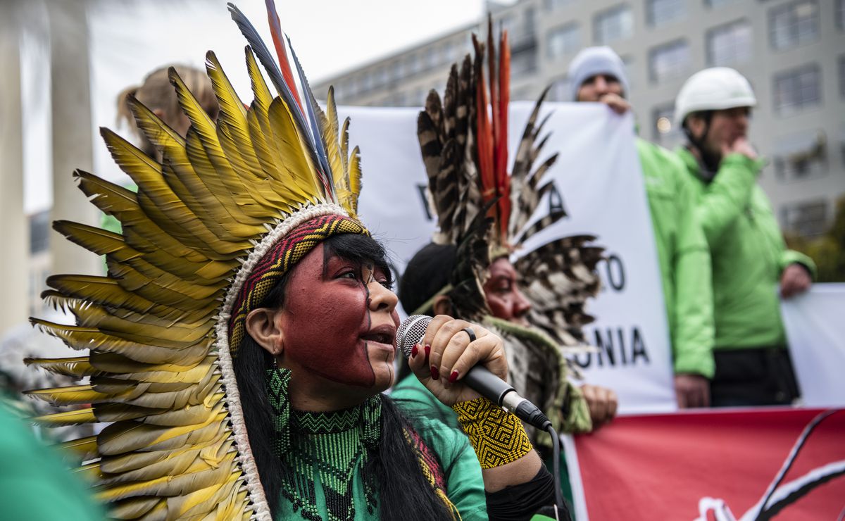 Members of an indigenous delegation from Brazil are standing in front of a hotel in Berlin, Germany.