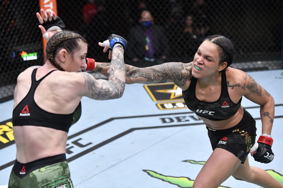 In this handout image provided by UFC, (R-L) Amanda Nunes of Brazil punches Megan Anderson of Australia in their UFC featherweight championship fight during the UFC 259 event at UFC APEX on March 06, 2021 in Las Vegas, Nevada