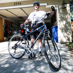 Lonnie Wollin poses for a portrait with his bike in front of his house in Cottonwood Heights on Saturday, July 11, 2020.