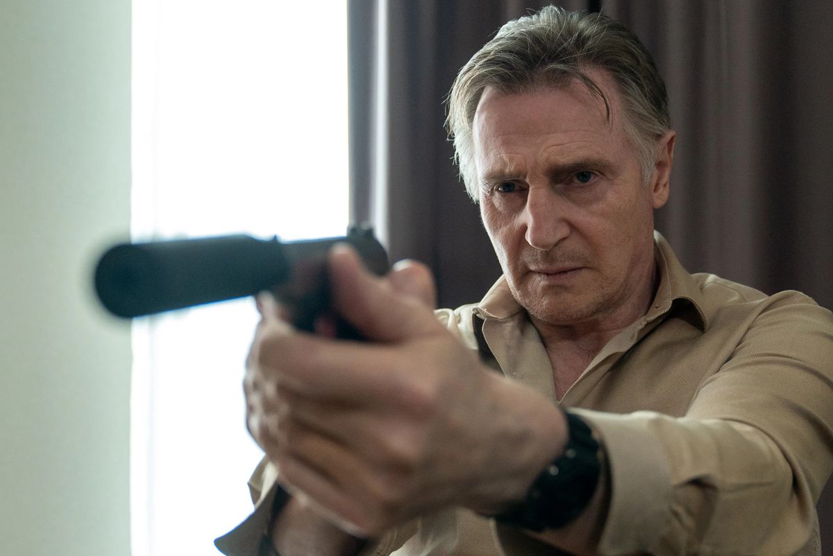 Liam Neeson as assassin Alex Lewis holding a pistol in Memory.