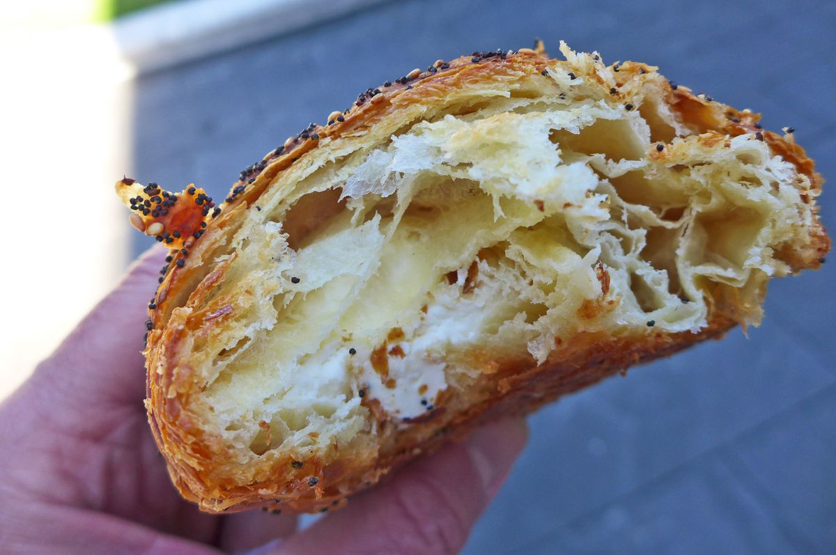 The croissant split in half to show a dense and creamy filling.