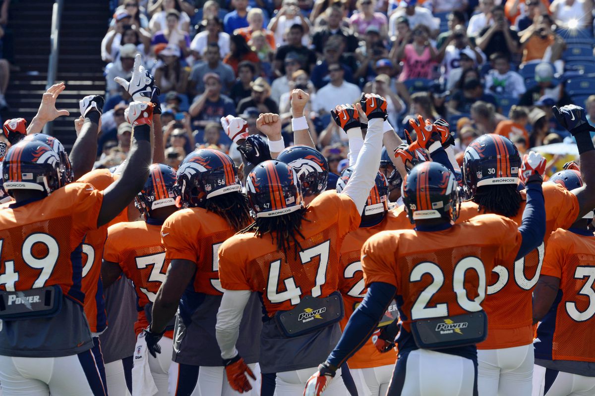 August 4, 2012; Englewood, CO, USA; Denver Broncos quarterback Peyton Manning (18) (center) leads the team in a huddle before the start of training camp drills at Sports Authority Field. Mandatory Credit: Ron Chenoy-US PRESSWIRE