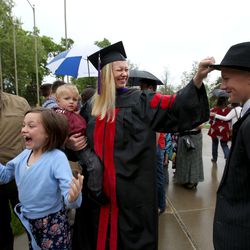 Kim Reeves holds son Gunnar and tugs on son Hunter's hat as daughter Brooke jumps and husband Jesse looks on after the S.J. Quinney College of Law commencement ceremony at the University of Utah in Salt Lake City on Friday, May 11, 2018. Reeves has two other children who are not pictured.