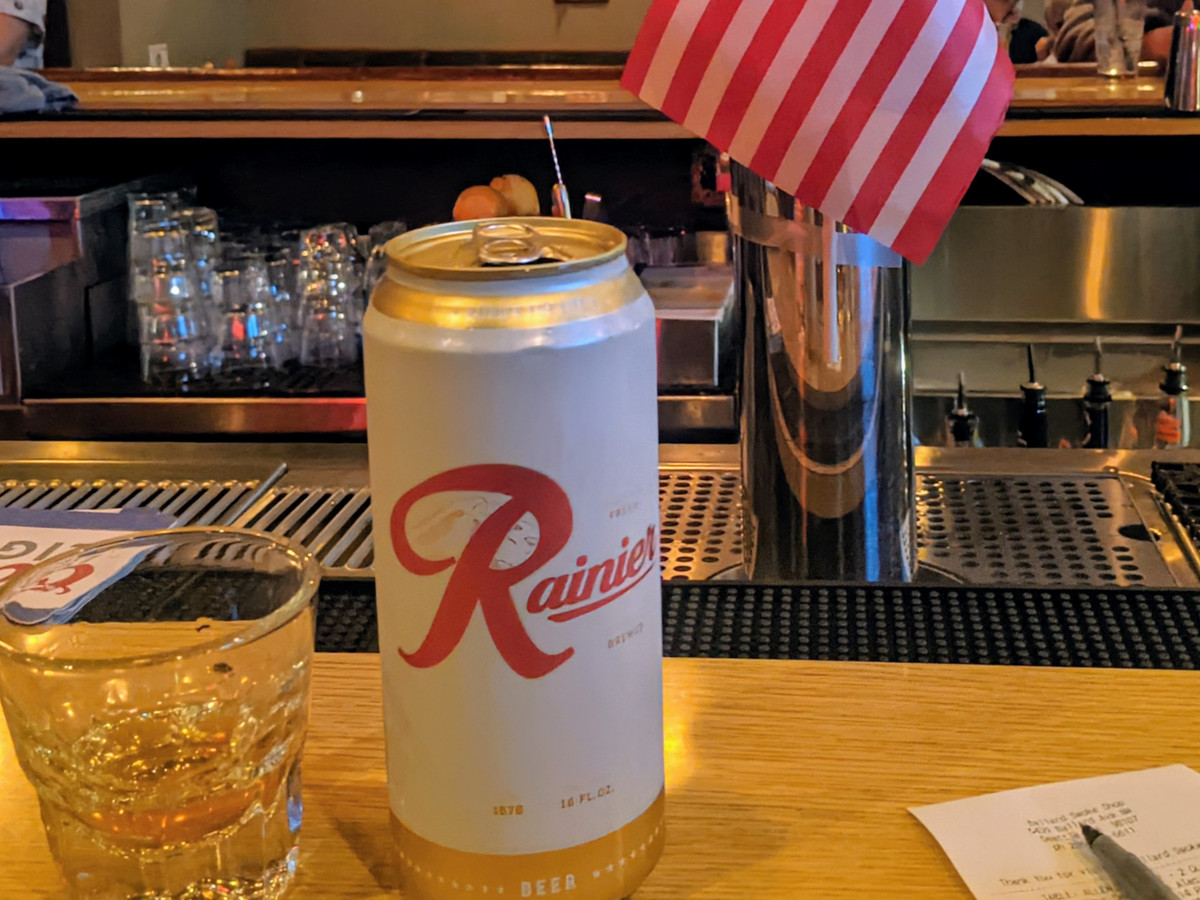 A can of Rainier on a bar next to an American flag
