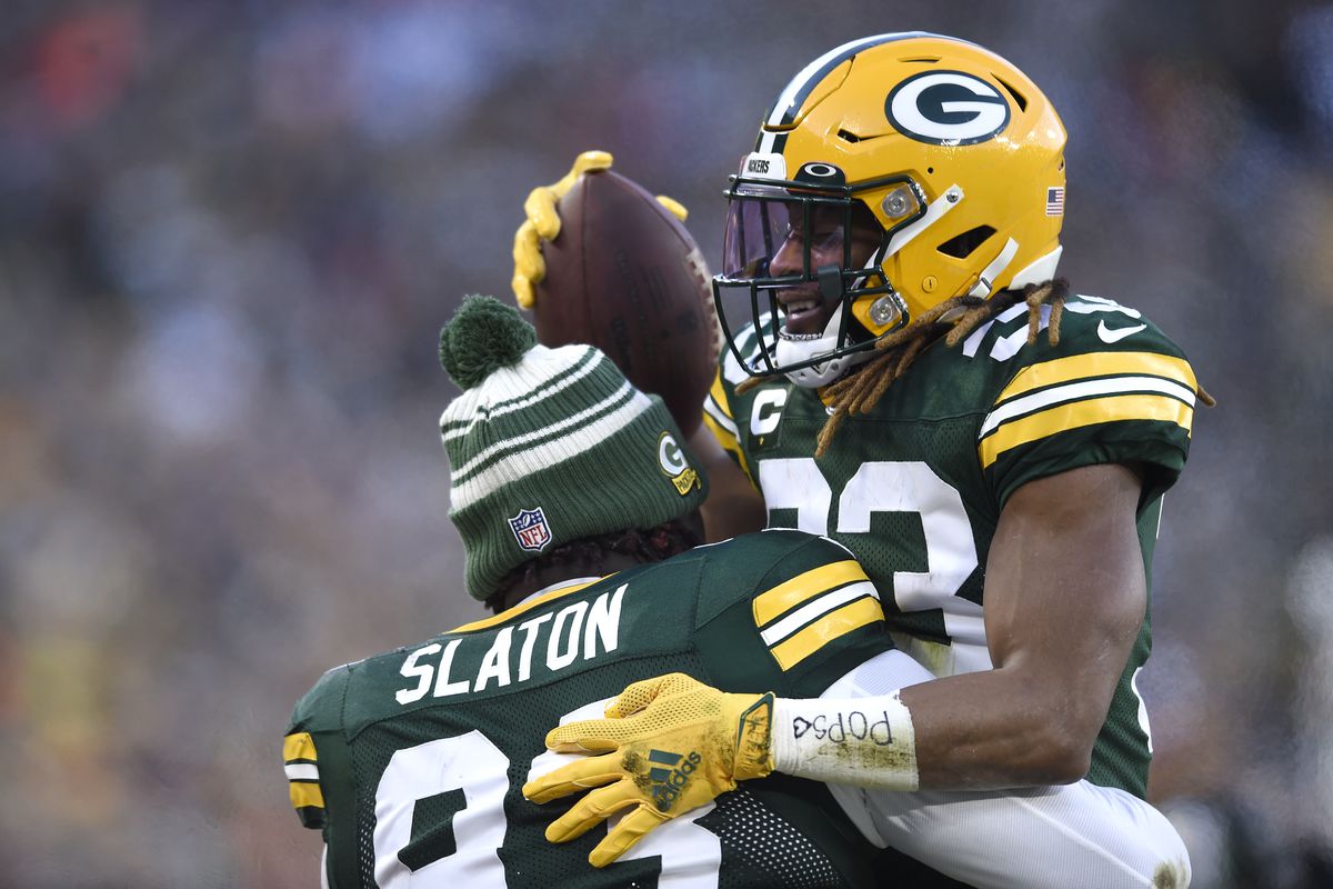 Aaron Jones #33 of the Green Bay Packers runs into T.J. Slaton #93 of the Green Bay Packers on the sidelines during the first quarter against the Minnesota Vikings at Lambeau Field on January 01, 2023 in Green Bay, Wisconsin.