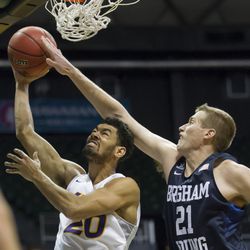 BYU forward Kyle Davis (21) attempts to block a shot by Northern Iowa guard Jeremy Morgan (20) in the second half of an NCAA college basketball game at the Diamond Head Classic, Friday, Dec. 25, 2015, in Honolulu. BYU won 84-76. (AP Photo/Eugene Tanner)