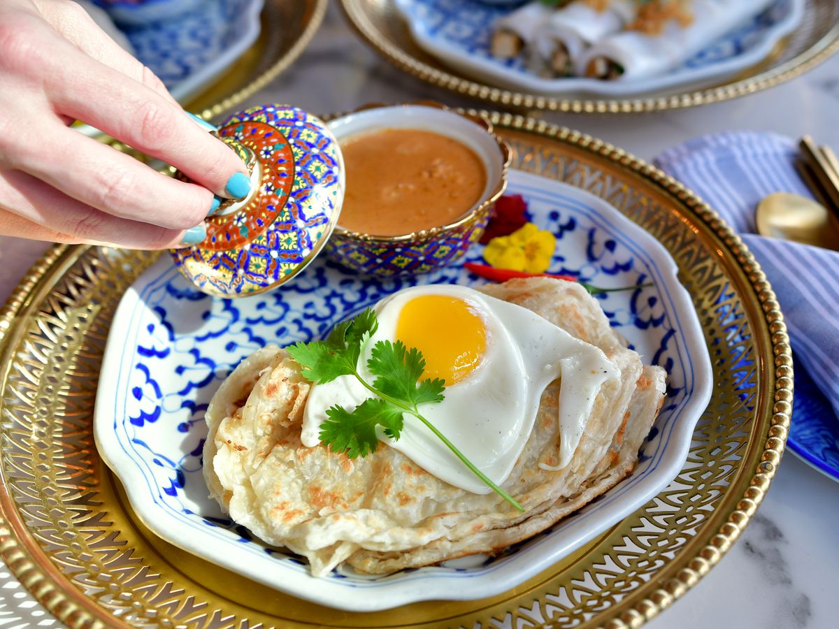 Roti with egg and curry in a decorative dish.