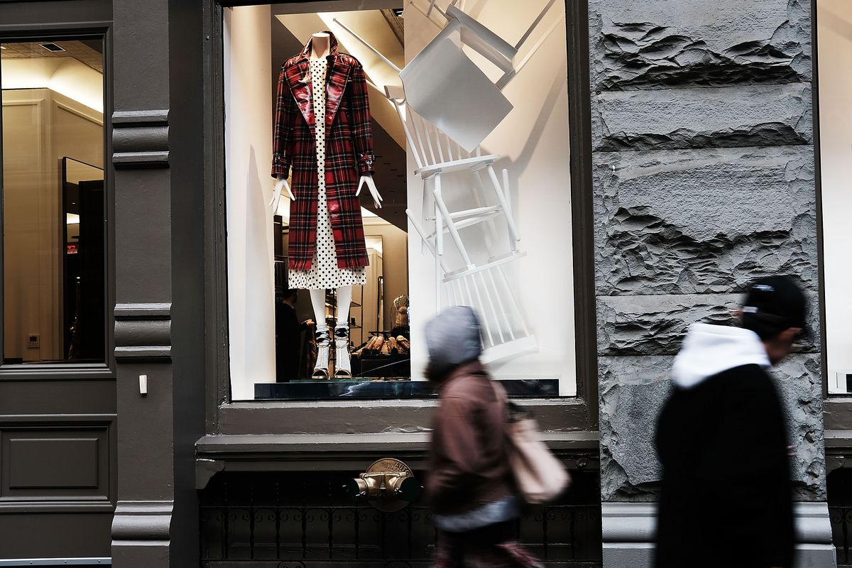 A shopper walks by a designer store window
