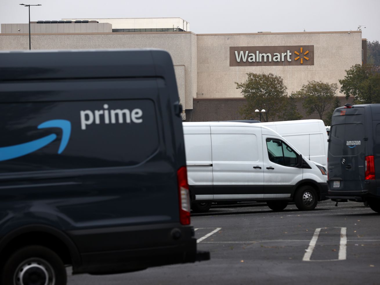 Amazon vans in front of a Walmart store.