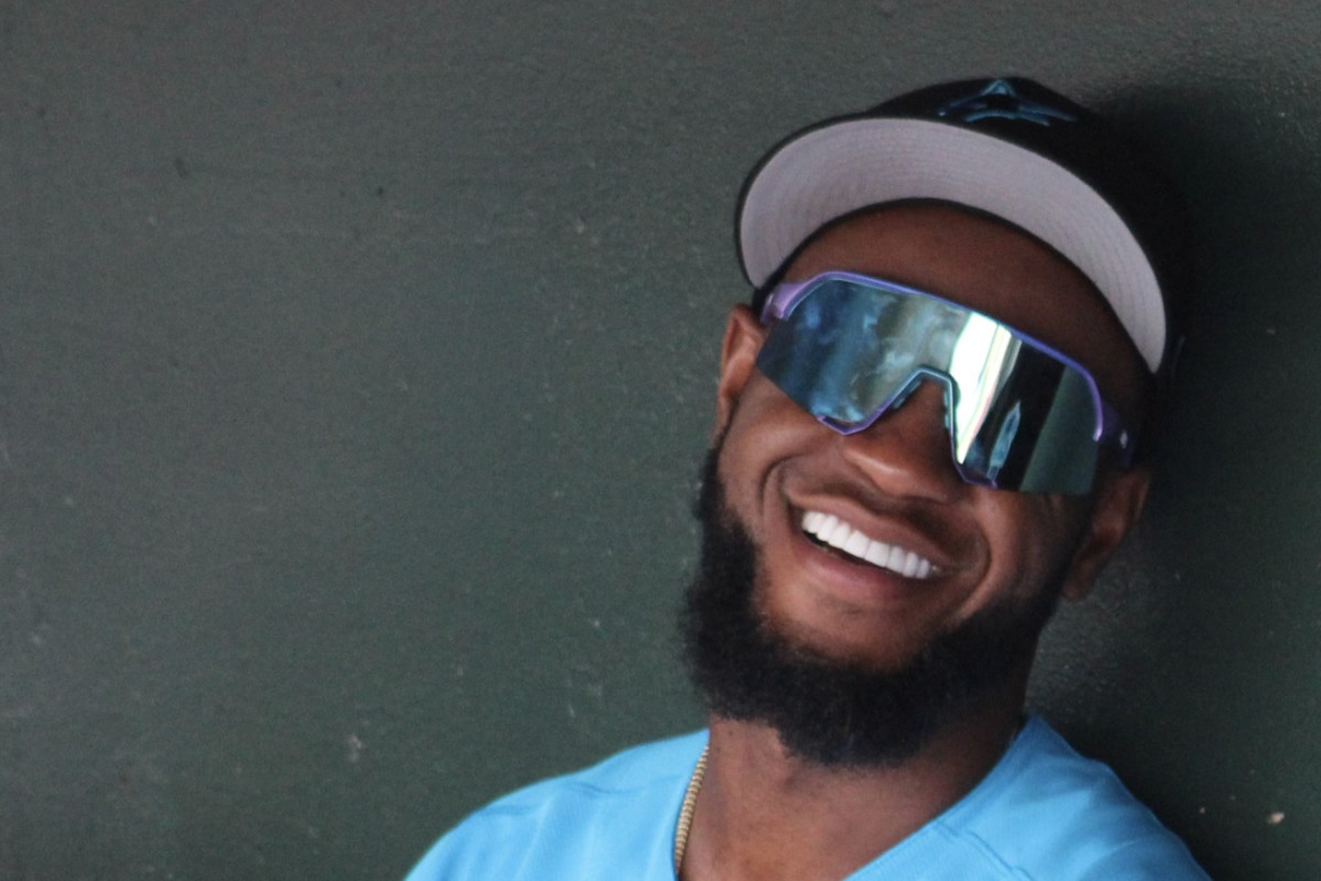 Bryan De La Cruz smiles in the dugout prior to the Marlins vs. Rays Grapefruit League game on March 11, 2023