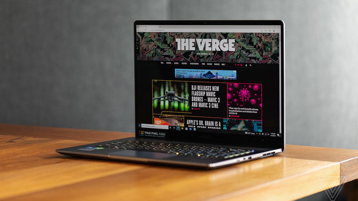 The MSI Creator Z16 open on a table angled to the left. The screen displays The Verge homepage.