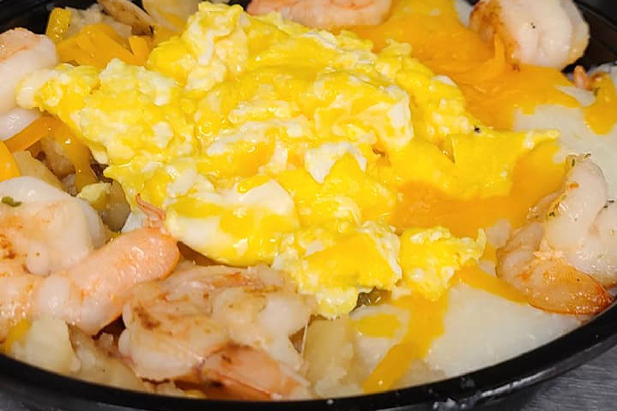 A bowl of shrimp, grits, and eggs