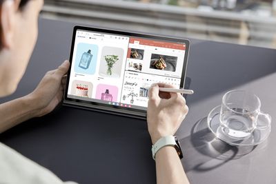 A person using the S Pen stylus on a Samsung Galaxy Tab S9 tablet.