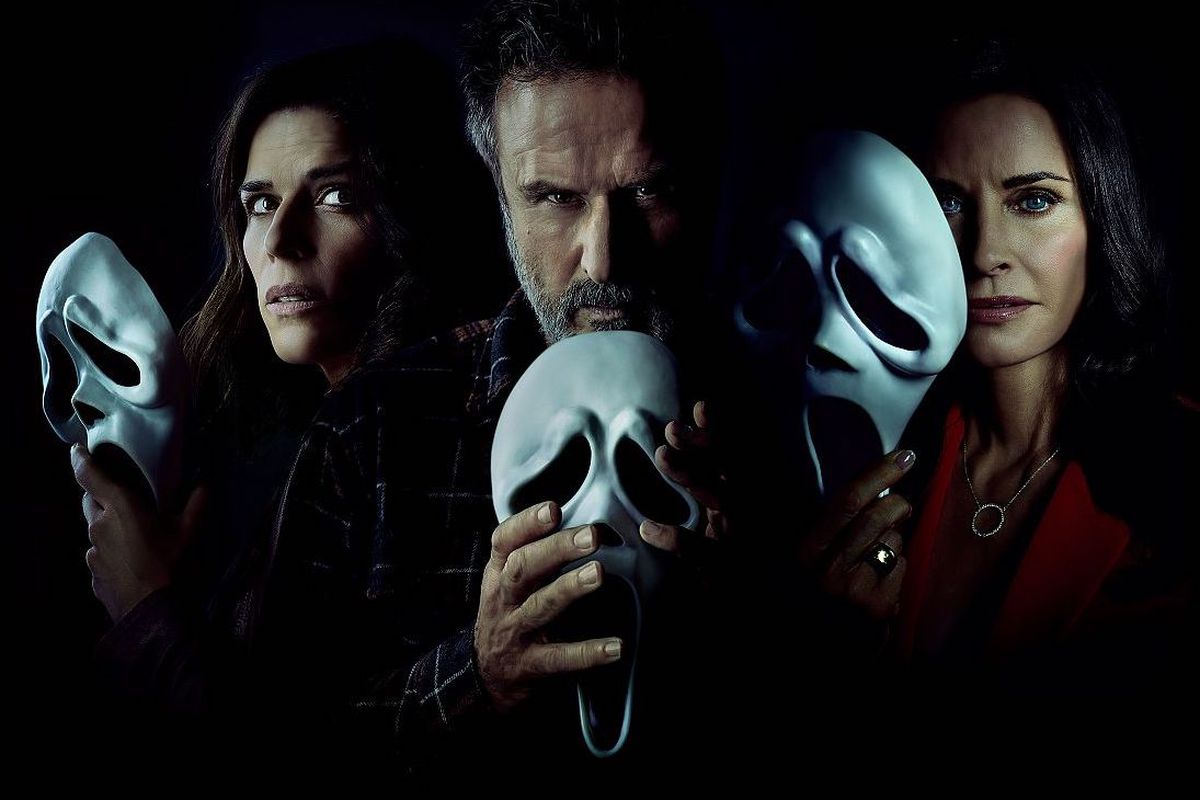 Neve Campbell, David Arquette and Courtney Cox’s Scream characters hold up ghostface masks