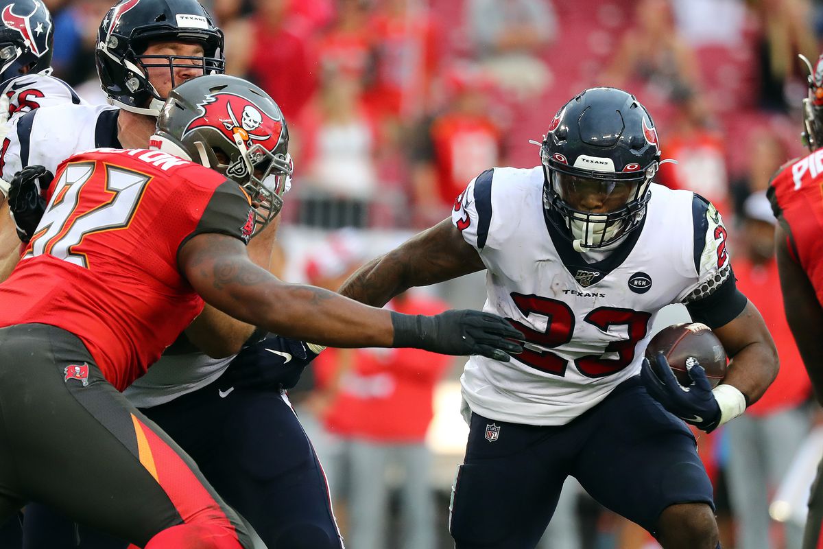 Houston Texans running back Carlos Hyde runs with the ball as Tampa Bay Buccaneers defensive tackle William Gholston defends during the second half at Raymond James Stadium