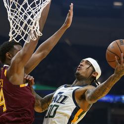 Utah Jazz’s Jordan Clarkson (00) drives to the basket again Cleveland Cavaliers’ Evan Mobley (4) in the first half of an NBA basketball game, Sunday, Dec. 5, 2021, in Cleveland. 