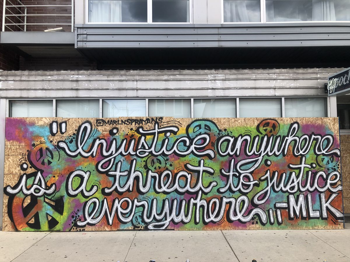 On boards outside Epoch Studio Salon in Wicker Park is a famous quote from the Rev. Martin Luther King Jr., painted by the street artist who goes by the name “Nzyme,” 22.