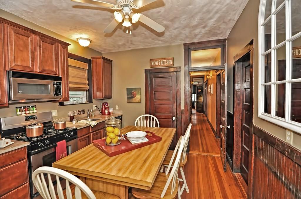 A snug kitchen with a table and chairs in the middle. 