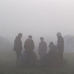Migrants stand around the remains of a fire on a foggy morning at the northern Greek border station of Idomeni, Tuesday, March 8, 2016. Up to 14,000 people are stranded on the outskirts of the village of Idomeni, with more than 36,000 in total across Greece, as EU leaders who held a summit with Turkey on Monday said they hoped they had reached the outlines of a possible deal with Ankara to return thousands of migrants to Turkey.