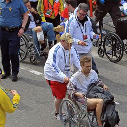 Workers aid injured people at the finish line of the 2013 Boston Marathon following an explosion in Boston, Monday, April 15, 2013. Two explosions shattered the euphoria of the Boston Marathon finish line on Monday, sending authorities out on the course to carry off the injured while the stragglers were rerouted away from the smoking site of the blasts. 