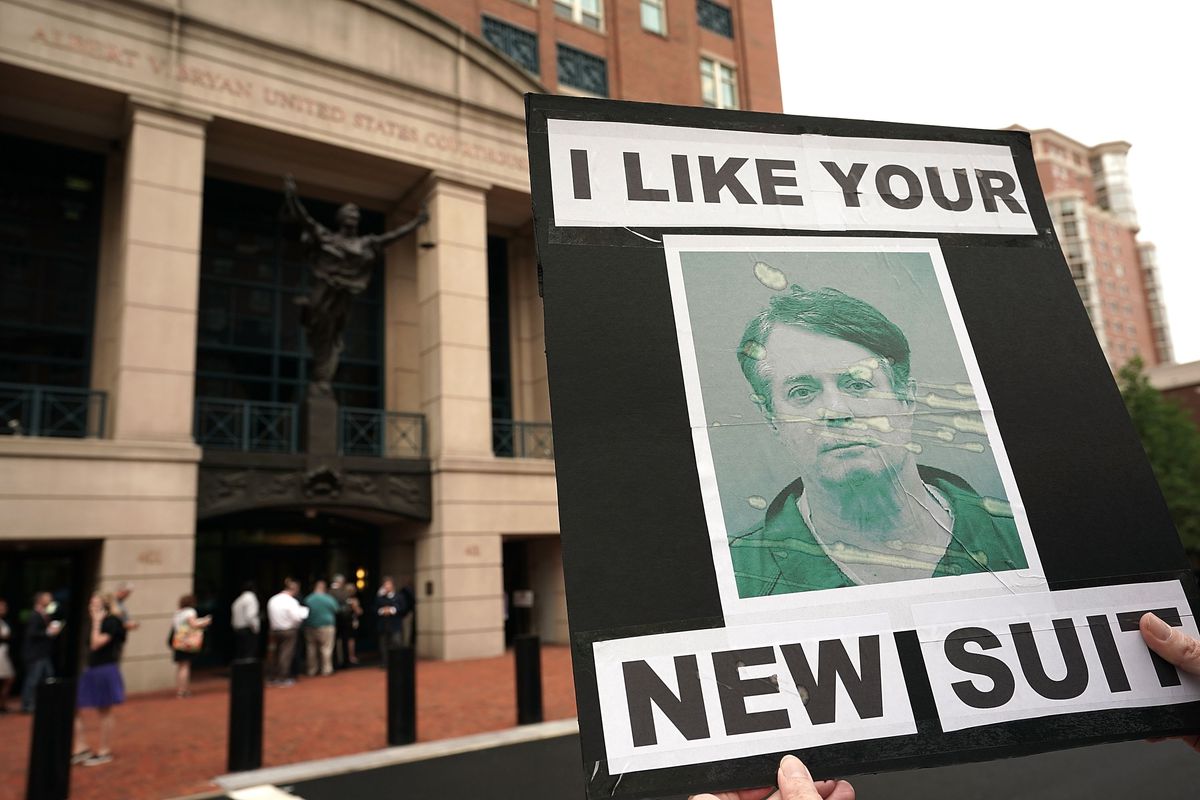 An activist holds a picture of former Trump campaign chairman Paul Manafort during a protest outside the Albert V. Bryan United States Courthouse prior to the first day of the trial of Manafort July 31, 2018 in Alexandria, Virginia.&nbsp;